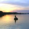 A fisherman enjoying a day on the Ohio River taking in the beautiful sun set.